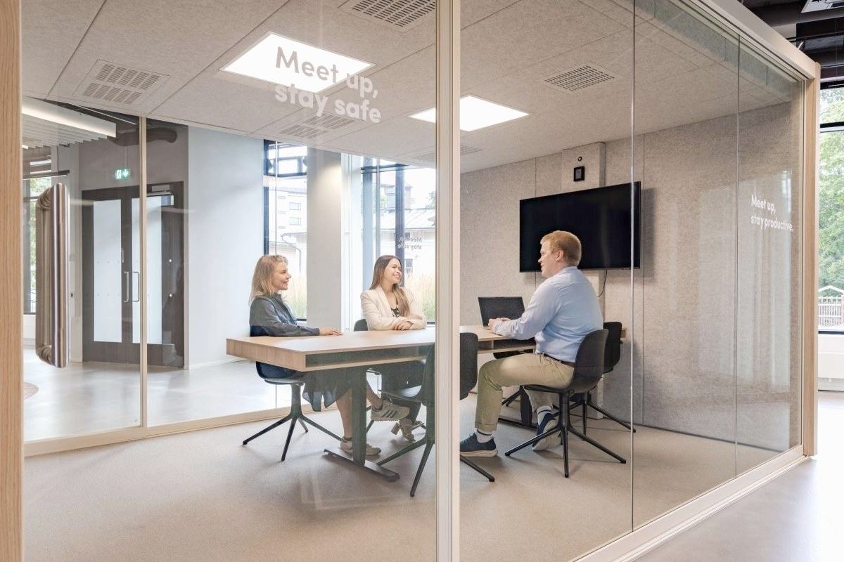 Tre personer i møte i en Vetrospace møtepod med glassvegger