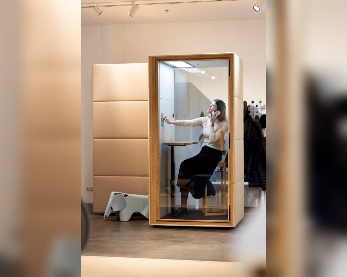 SilentLab SPOT telefonbås – kvinna som pratar i telefon vid bordet i båset