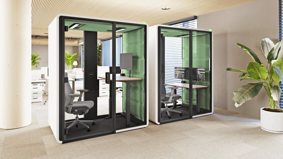 To HushFree stillerom fra Hushoffice med arbeidsplass i et kontorlandskap